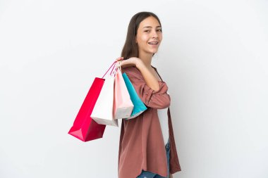 Beyaz arka planda izole edilmiş genç bir Fransız kız alışveriş torbaları tutuyor ve gülümsüyor.
