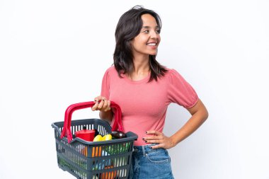 Elinde yiyecek dolu bir sepet tutan genç bir kadın.