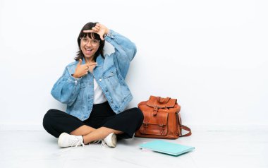 Genç bir bayan öğrenci, beyaz arka planda izole bir şekilde oturuyor. Yüzüne odaklanıyor. Çerçeve sembolü