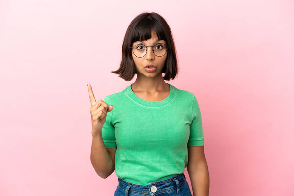 Молодая женщина смешанной расы изолированы на розовом фоне, намереваясь реализовать решение при поднятии пальца