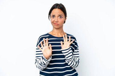 Young hispanic woman isolated on white background nervous stretching hands to the front