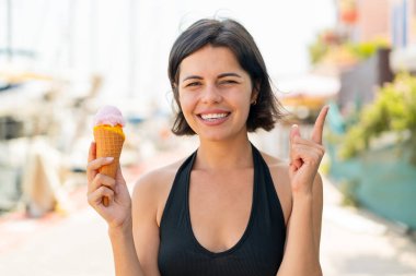 Açık havada kornet dondurması olan genç, güzel Bulgar kadın harika bir fikri işaret ediyor.