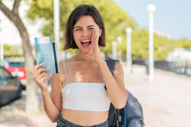 Genç, güzel bir Bulgar kadın elinde pasaport, ağzı açık bağırıyor.