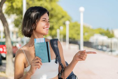 Açık havada pasaportu olan genç, güzel bir Bulgar kadın bir ürün sunmak için kenarı işaret ediyor.