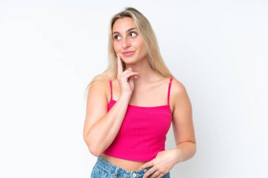 Beyaz arka planda izole edilmiş genç beyaz kadın yukarı bakarken bir fikir düşünüyor.