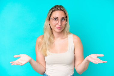 Mavi arka planda soyutlanmış, gözlüklü ve şüpheleri olan beyaz bir kadın.