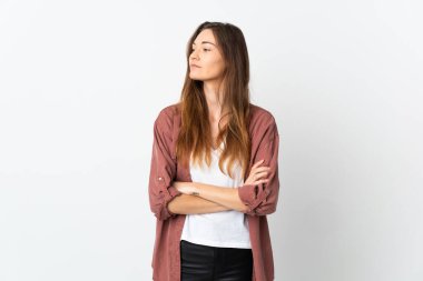 Beyaz arka planda izole edilmiş genç İrlandalı kadın yan tarafa bakıyor.