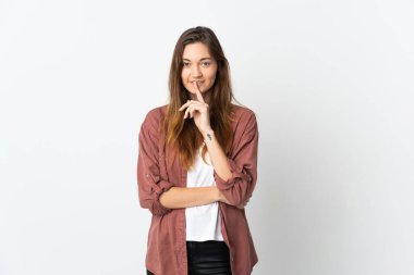 Beyaz arka planda izole edilmiş genç İrlandalı kadın parmağını ağzına sokan sessiz bir jest işareti gösteriyor.