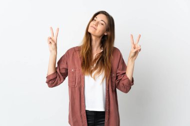 Beyaz arka planda izole edilmiş genç İrlandalı kadın iki eliyle zafer işareti gösteriyor.