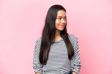 Pembe arka planda izole edilmiş genç Kolombiyalı kadın.