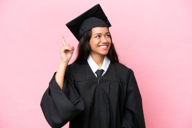 Kolombiyalı genç bir üniversite mezunu pembe arka planda izole edilmiş bir şekilde parmağını kaldırarak çözümü bulmaya çalışıyor.