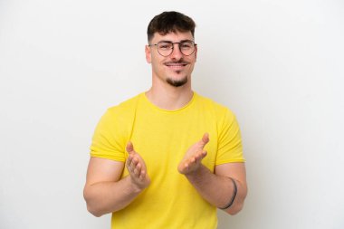 Beyaz arka planda izole edilmiş beyaz tenli yakışıklı bir adam bir konferanstan sonra alkışlıyor.