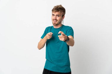 Beyaz arka planda soyutlanmış genç yakışıklı adam öne bakıyor ve gülümsüyor.