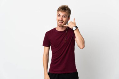 Beyaz arka planda izole edilmiş genç yakışıklı bir adam telefon jesti yapıyor. Bana geri dönüş işareti ver.