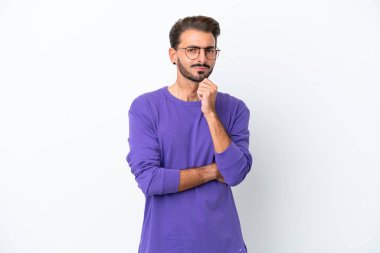 Beyaz arka planda soyutlanmış genç beyaz bir adamın şüpheleri ve düşünceleri var.