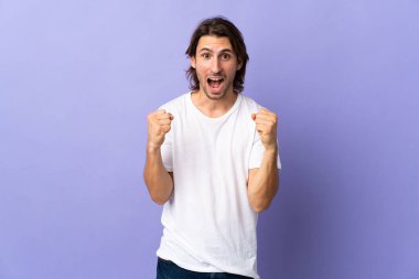 Mor arka planda kalan yakışıklı genç adam galibiyeti kutluyor.