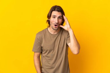 Sarı arka planda izole edilmiş genç yakışıklı bir şey fark etti ve çözümü arıyor.