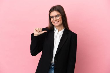 Genç beyaz kadın pembe arka planda soyutlanmış gururlu ve kendini beğenmiş.