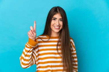 Mavi arka planda izole edilmiş beyaz bir kadın harika bir fikre işaret ediyor.