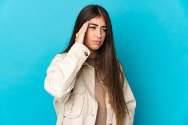 Kafkasyalı genç bir kadın mavi arka planda izole edilmiş, baş ağrısı var.