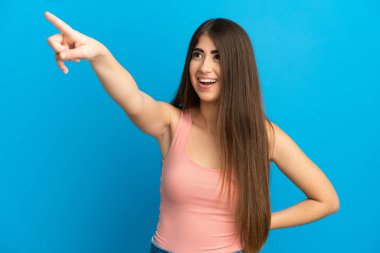 Mavi arka planda izole edilmiş genç beyaz kadın...