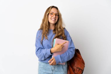 Beyaz arka planda izole edilmiş genç bayan bir ürünü sunmak için kenarı işaret ediyor.