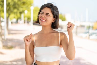 Açık havada zaferi kutlayan gözlüklü genç, güzel Bulgar kadın.