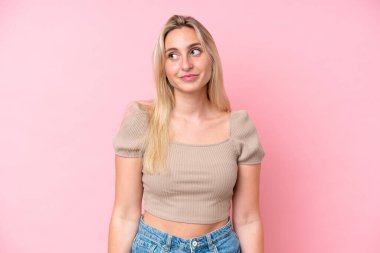 Pembe arka planda izole edilmiş beyaz bir kadın. Taraf ararken şüphe duyuyor.