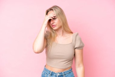 Pembe arka planda izole edilmiş, başı ağrıyan beyaz bir kadın.