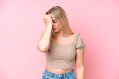 Pembe arka planda izole edilmiş, başı ağrıyan beyaz bir kadın.