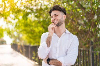 Dışarıdaki yakışıklı adam yan tarafa bakıyor.