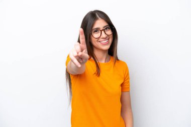 Beyaz arka planda izole edilmiş genç beyaz kadın parmağını kaldırıyor ve gösteriyor.