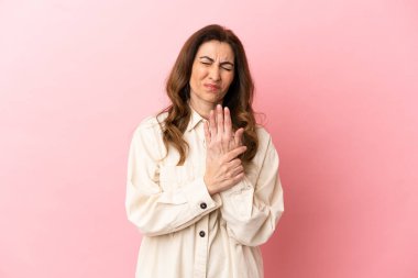 Orta yaşlı beyaz kadın pembe arka planda izole edilmiş ellerinde acıdan muzdarip