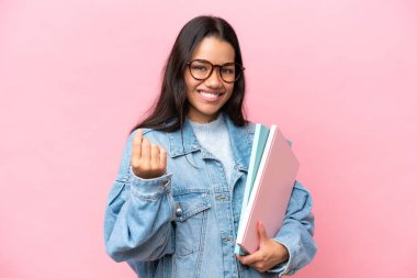 Young student Colombian woman isolated on pink background making money gesture