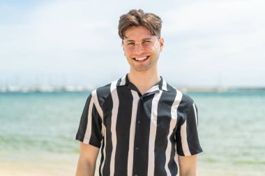 Gözlüklü ve mutlu yüzlü genç yakışıklı adam.