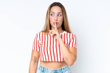 Beyaz arka planda izole edilmiş beyaz bir kadın sessiz bir jest işareti gösteriyor. Parmağını ağzına sokuyor.