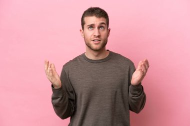 Pembe arka planda izole edilmiş genç beyaz adam bunalıma girdi.
