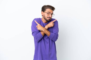 Beyaz arka planda izole edilmiş beyaz tenli genç adam, yan taraftakilerin şüphelerine işaret ediyor.