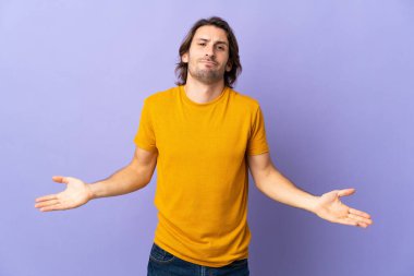 Mor arka planda izole edilmiş genç yakışıklı adamın şüpheleri var.