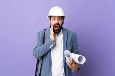 Miğferli genç bir mimar, elinde yalıtılmış mor bir arka plan, şaşırmış ve şok olmuş bir yüz ifadesi var.