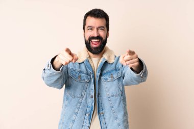 Sakallı, soyutlanmış, şaşırmış ve ön tarafı işaret eden beyaz bir adam.