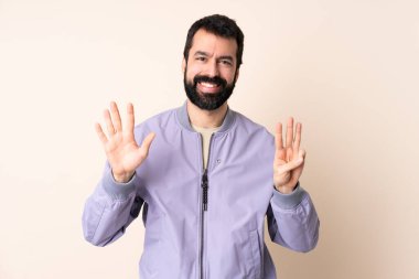 Sakallı, ceketli, soyutlanmış arka planda beyaz bir adam.