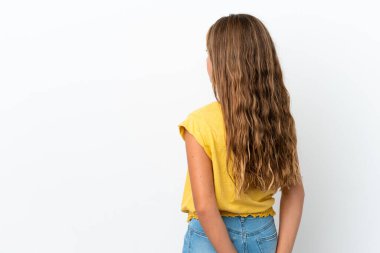 Beyaz arka planda izole edilmiş küçük beyaz bir kız. Arkasına bakıyor.