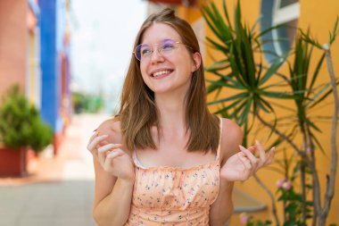 Açık havada sürekli gülümseyen gözlüklü genç Fransız kız.