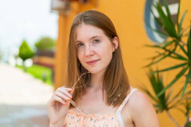 Açık havada genç bir Fransız kız Neşeli gözlükleriyle