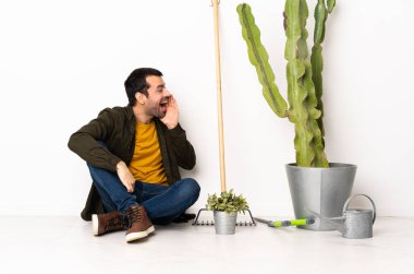 Bahçıvan içeride yerde oturuyor ve ağzı açık bağırıyor.