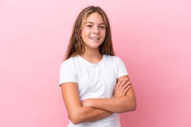 Küçük beyaz kız pembe arka planda izole edilmiş, kolları bağlı ve ileriye bakıyor.