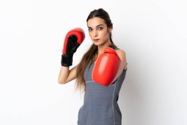 Beyaz arka planda boks eldivenli, beyaz tenli genç bir kadın.