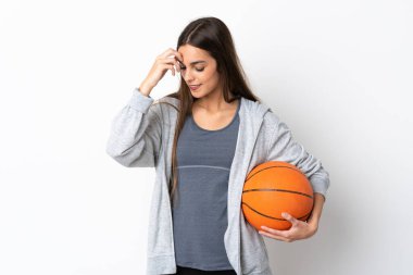 Basketbol oynayan genç bir kadın beyaz arka planda yalnız gülüyor.