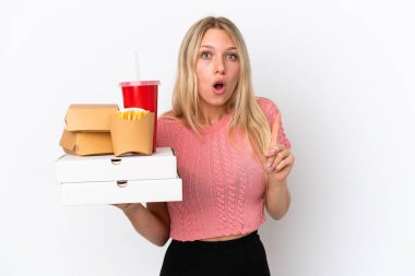 Mavi arka planda yağlı yiyecekler tutan beyaz bir kadın çözümü bulmak için parmağını kaldırıyor.